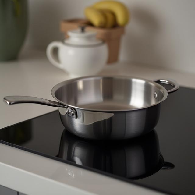 En stilren Sonos-serie gryta på en modern induktionshäll, som reflekterar ljus och textur.